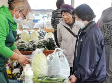 新鮮な野菜の買い物を楽しむ住民ら