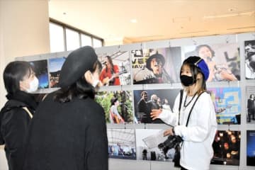 写真について来場者に説明する石井さん（右）