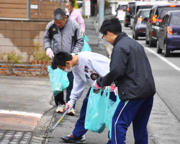桜マラソンを気持ちよく走ってもらおうと、ごみを拾う参加者たち＝佐賀市高木瀬西