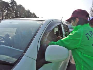 桜の枝を手渡すスタッフ（右）（八戸公園提供）