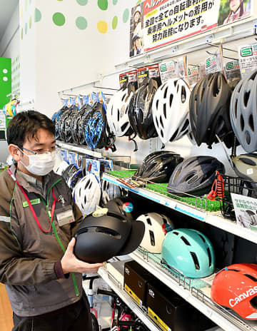 改正道交法の施行を見据え、自転車用ヘルメットの売り場を拡大した販売店。帽子状につばが付いた商品もある＝天童市