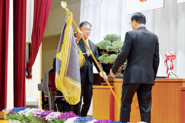 小林哲也市長（右）に校旗を返納する秋元敏行校長＝18日午前、熊谷市立星宮小学校
