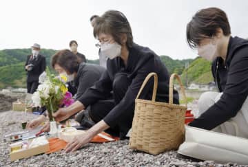 秋田県男鹿市の加茂青砂海岸で、海に向かって花を手向ける遺族ら＝26日午後