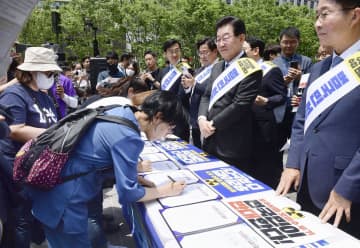 東京電力福島第1原発の処理水海洋放出に反対する署名運動を始めた、韓国の野党「共に民主党」の李在明代表（右から2人目）ら＝26日、ソウル（共同）