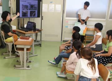 田中さん（左）から戦争遺構について学ぶ児童＝平戸市、野子小