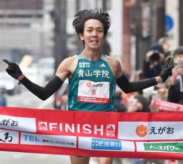 男子1位でフィニッシュする鶴川正也（青山学院大、九州学院高出）＝16日午前、熊本市中央区のびぷれす熊日会館前（上杉勇太）