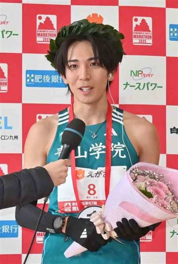 熊日30キロロードレースで優勝し、インタビューに答える鶴川正也選手（青学大）＝16日午前、熊本市中央区のびぷれす広場（後藤仁孝）