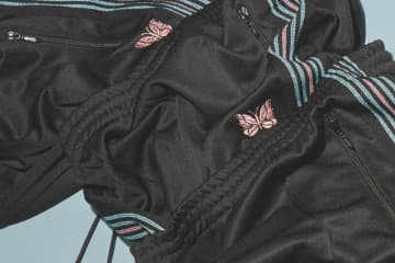 ニードルズ×ラブレスの限定トラックパンツ第4弾、“ラメ糸輝く”サイドラインやピンクのパピヨン刺繍