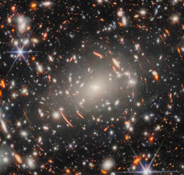 不思議な光の弧に包まれた銀河団「Abell S1063」 ジェームズ・ウェッブ宇宙望遠鏡が観測