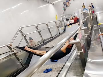 地下鉄の階段の手すりにハンモック張って寝る男性＝中国ネット「ひどすぎ」「モラルない」