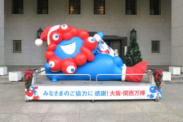 ミャクミャクが「こみゃくプレゼント袋」担いでゴロン、市役所前でサンタに変身