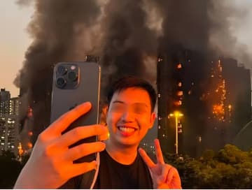香港火災をバックに笑顔で自撮り、男が拘束される