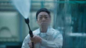 香川照之　不安にも必死にも見える表情で窓ガラスをホースで清掃する姿　「災 劇場版」場面写真