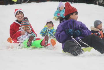 箱根園に雪遊び楽しめる特設ゲレンデお目見え　サンタ姿でそり滑りに歓声