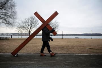 悲嘆に暮れる地域社会へやってくる3メートルの十字架、背負って歩く男性に話を聞く　米国