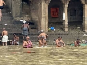 サンタ帽の沐浴で騒ぎに、インド　ガンジス川、日本人旅行者か