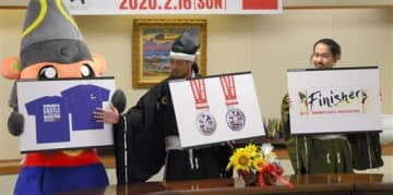 お披露目された熊本城マラソン第９回大会の参加賞のデザイン。左側からＴシャツ、フル完走者向けのメダル、タオル＝熊本市役所