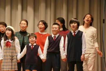 「取手市民のうた〜新しい明日〜」のレコーディングでコーラス参加者と一緒に歌う歌手の谷本貴義さん(右端)=同市藤代(同市提供)