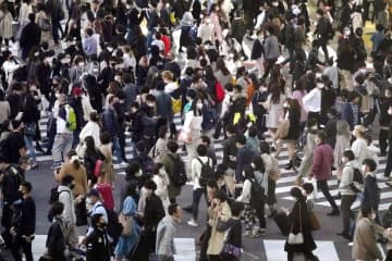 東京・渋谷のスクランブル交差点をマスク姿で歩く大勢の人たち=21日午後