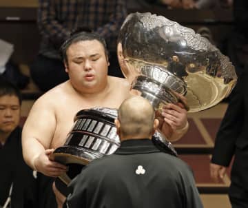大相撲11月場所で優勝し、日本相撲協会の八角理事長(手前)から内閣総理大臣杯を受け取る大関貴景勝=両国国技館