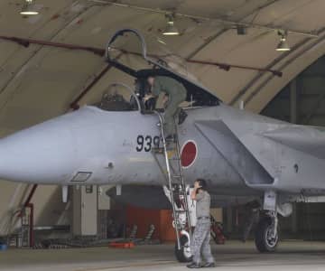 ニュース画像：サイレンが鳴り響くなか、F15戦闘機の操縦席に駆け込むパイロット＝2015年、航空自衛隊那覇基地