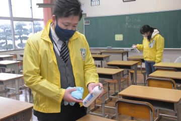 学校の教室で除菌作業を行うダイナムの従業員=稲敷市八千石