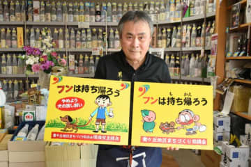 選挙ポスター掲示板の廃材を使い手書きでペットふん害防止を呼びかける看板を作っている平瀬修さん
