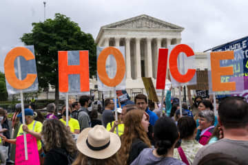 米連邦最高裁の前で「CHOICE」のプラカードを掲げて中絶の違法化に抗議し、女性の選択権を保障するよう訴えるデモ＝14日、ワシントン（AP＝共同）