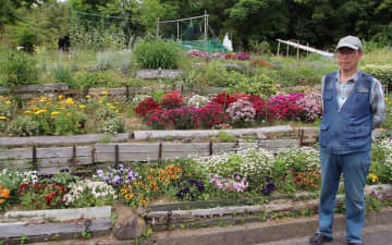 江口さん（右）ら「百合乃会」が長年世話した花壇。3月末で管理を終え、雑草も増えてきた＝時津町元村郷
