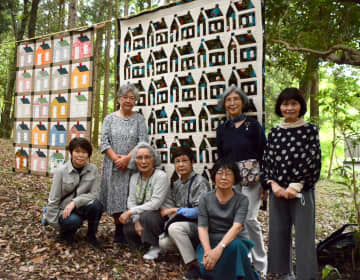 「ハウス」をテーマに作品展を開いている谷口知子さん（左から2人目）ら愛好家。右の作品は熊本地震で全壊した谷口さんの自宅から救出した布地で仕上げたタペストリー＝西原村