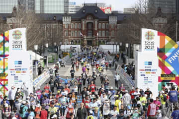 東京マラソンでゴールする市民ランナーら。奥は東京駅＝3月、東京都千代田区（代表撮影）