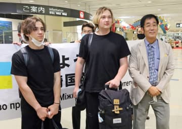 安東学長（右）が出迎える中、長崎空港に到着したザカーさん（中央）とマクシムさん（左）＝大村市
