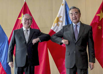 フィリピンのロクシン外相（左）と写真に納まる中国の王毅国務委員兼外相＝2021年1月、マニラ（新華社＝共同）