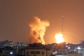 5日、パレスチナ自治区ガザで、イスラエル軍の空爆中に立ち上る煙と炎（ロイター＝共同）
