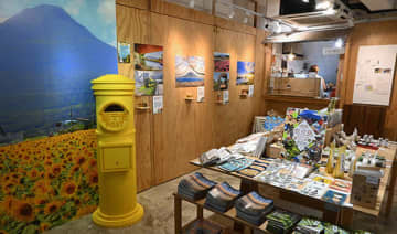 店内には「幸せを届ける黄色いポスト」が設置され、絵はがきを投函して鹿児島旅行を疑似体験できる＝21日、深水ホ（ＮＮＡ撮影）