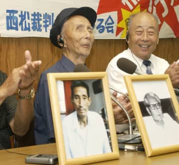 ２００４年７月、広島高裁で逆転勝訴し、仲間の遺影を前に記者会見で笑顔を見せる原告の（左から）宋継堯さん、邵義誠さん＝広島市