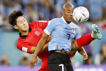 ウルグアイ―韓国　試合終了間際、激しく競り合う韓国の李剛仁（左）とウルグアイのデラクルス＝アルラヤン（共同）