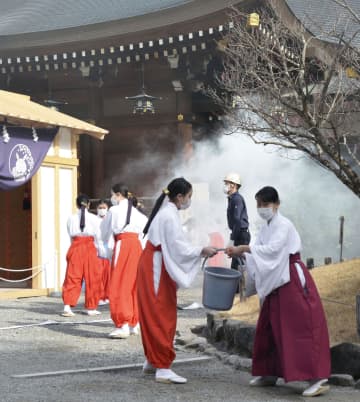 大神神社で実施された消火訓練で、バケツリレーをする巫女ら＝25日午後、奈良県桜井市