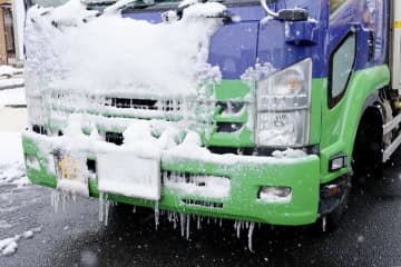 大雪のため東名阪自動車道が通行止めとなり、亀山インターチェンジ付近で待機するトラックに付着した雪やつらら＝25日午後3時21分、三重県亀山市