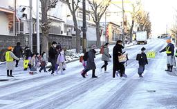 凍結した道を登校する児童ら＝25日午前8時2分、灘区高羽町4
