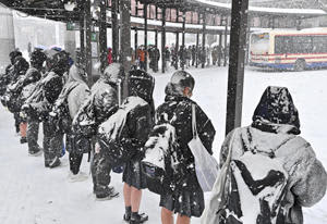 寒さをこらえてバスを待つ高校生ら＝25日午前7時40分、JR福島駅前のバスターミナル