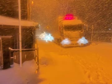 雪の中、立ち往生するトラック＝24日午後8時半ごろ、智頭町中原（葉狩さんのツイッターより）
