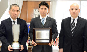 松浦会長（右）から表彰状を受けた赤堀前主将（中央）。左は横山部長