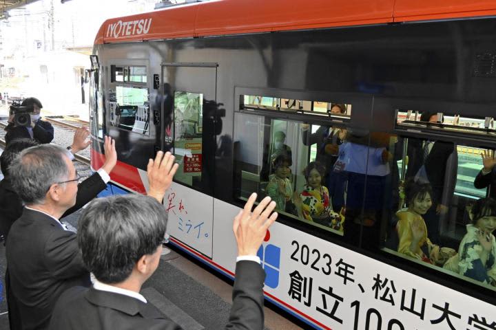松山大100周年ラッピング路面電車登場　24年3月末まで運行　大学ロゴの赤と青を基調にデザイン