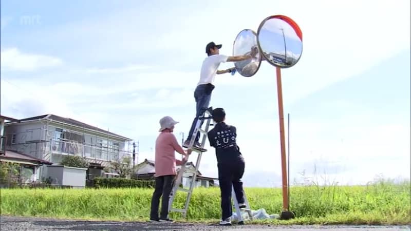 Volunteers cleaning curved mirrors in Ebino City
