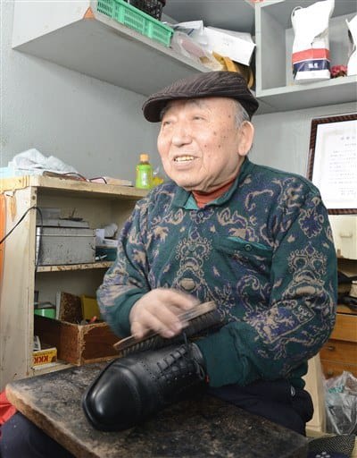 靴を磨きながら常連客との会話を楽しむ鈴木田袈裟雄さん