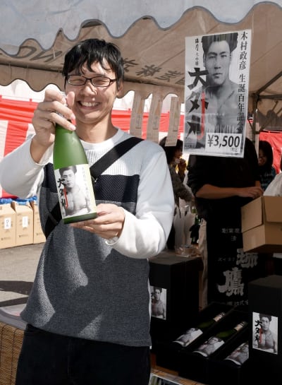 木村政彦氏にちなんだ大吟醸酒「大外刈」を手に笑顔を見せる購入客