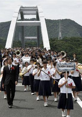 大矢野中吹奏楽団を先頭に、新天草１号橋（天城橋）の渡り初めをする関係者たち