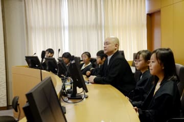 裁判劇の判決言い渡しでは、法服をまとった小学生たちが並んだ。中央は県弁護士会の奥田律雄会長=佐賀市の佐賀地裁