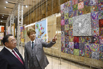 18日、パリで開かれた展覧会の内覧会で木寺昌人駐フランス大使(左)に作品を説明する香取慎吾さん(共同)